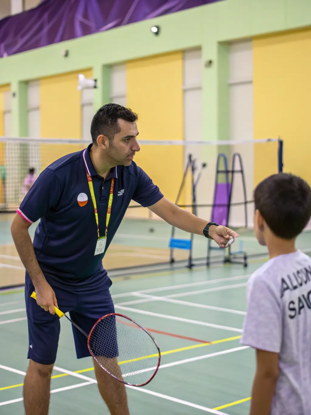 A focused image of a coach providing personalized instruction to a handball player at HBCO HANDBALL CLUB OBJAT CORREZE, emphasizing skill development.